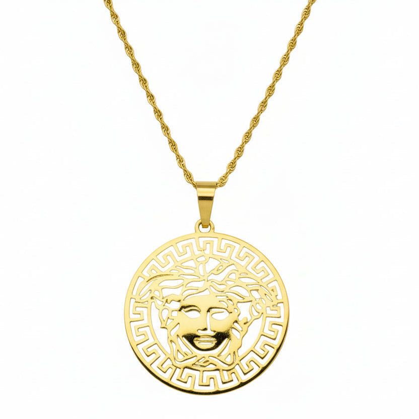 Gold necklace with a Medusa head pendant on a white background