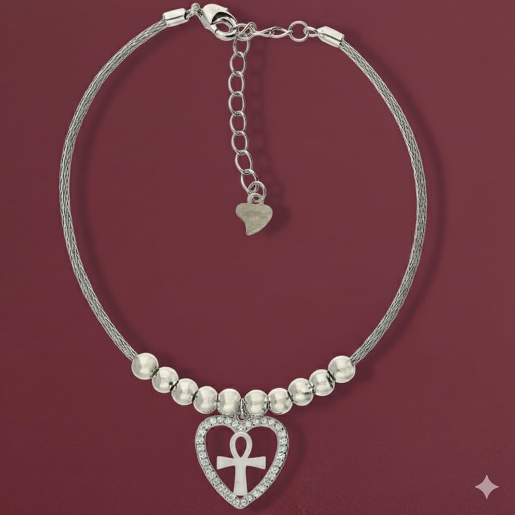 Silver bracelet with heart-shaped Ankh charm on a red background