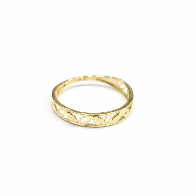 Gold ring with cut-out design on a gray background